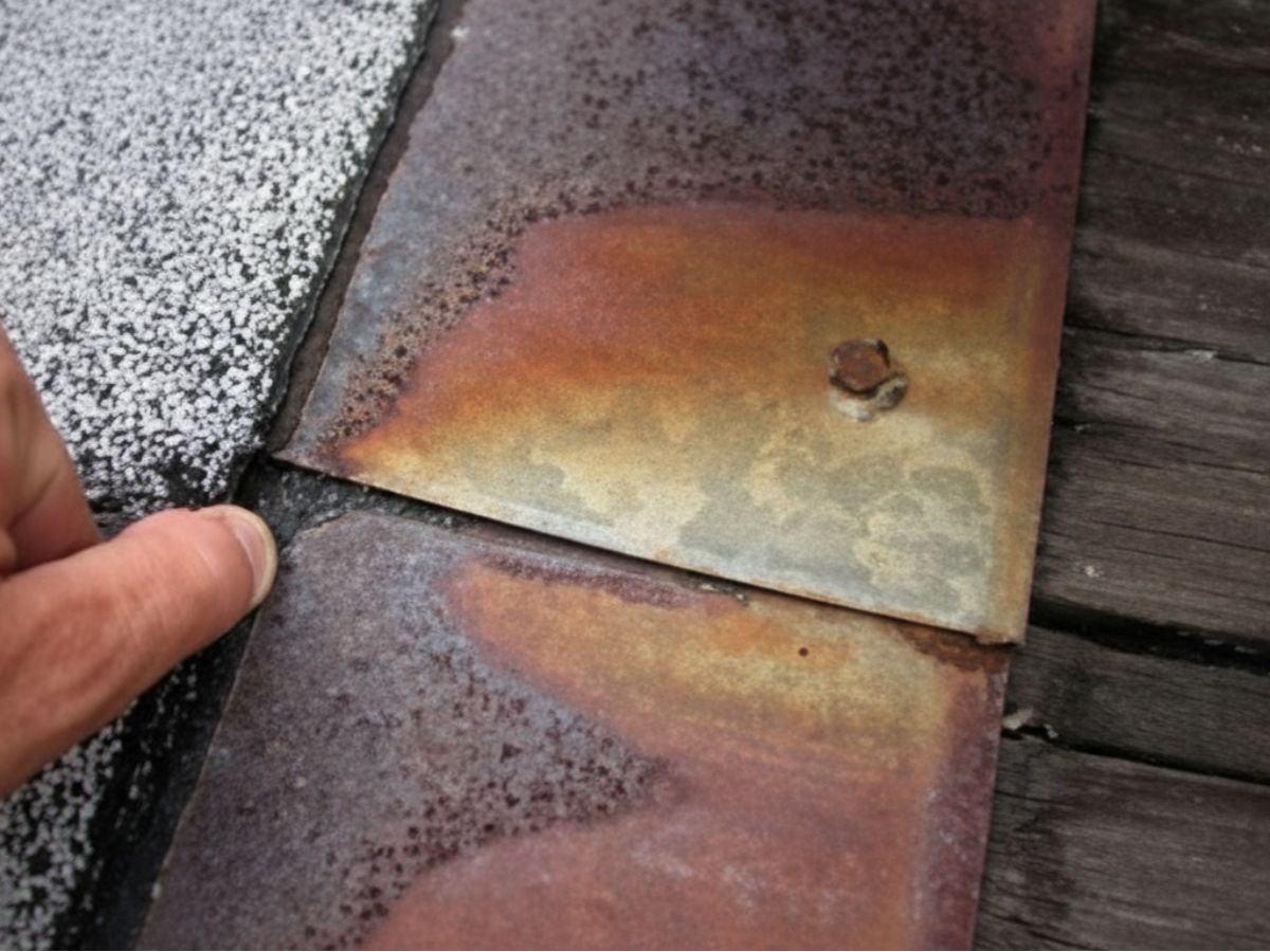 Metal roof panel overlap detail at roof edge with fastener visible