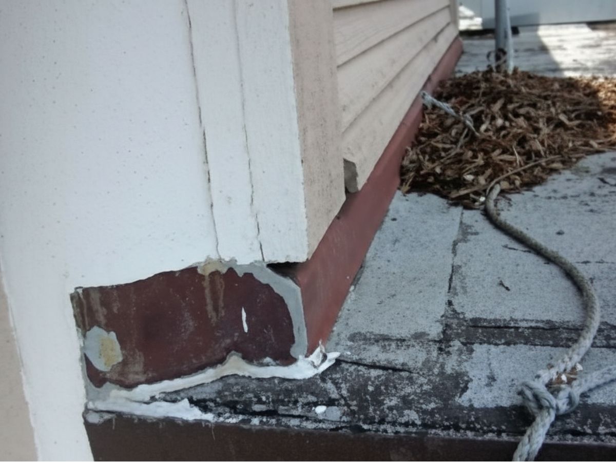 Exterior wall base detail where siding meets flat roof surface