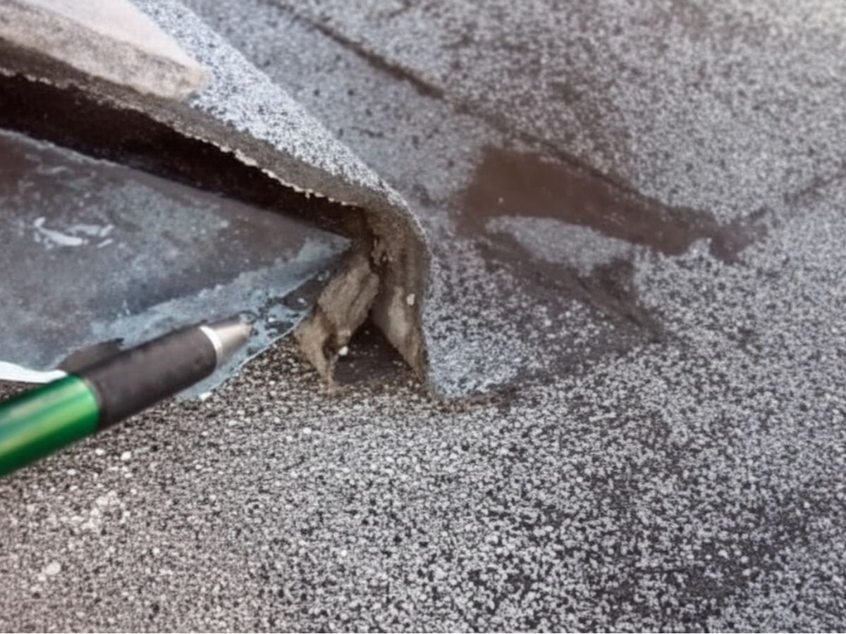 Close-up of flat roof membrane at a corner detail with metal edge and surface coating
