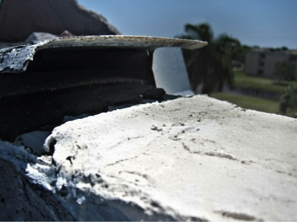 Roof vent termination with metal cap and flashing at roof surface