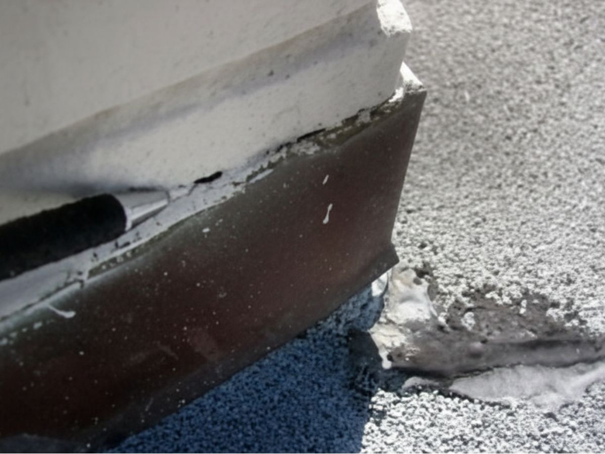 Exterior wall base and flat roof surface junction detail