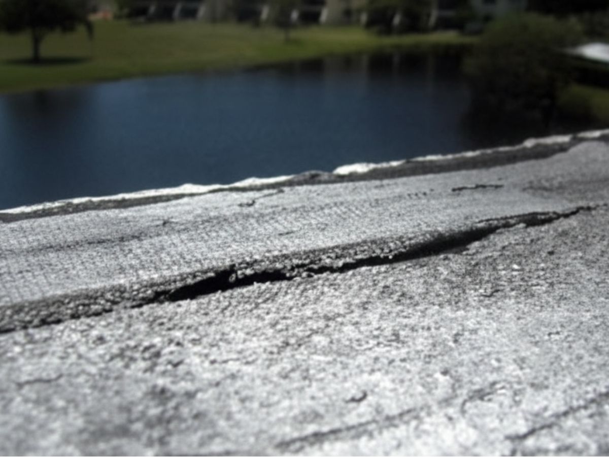 Close-up of cracked roof membrane seam showing potential water intrusion point