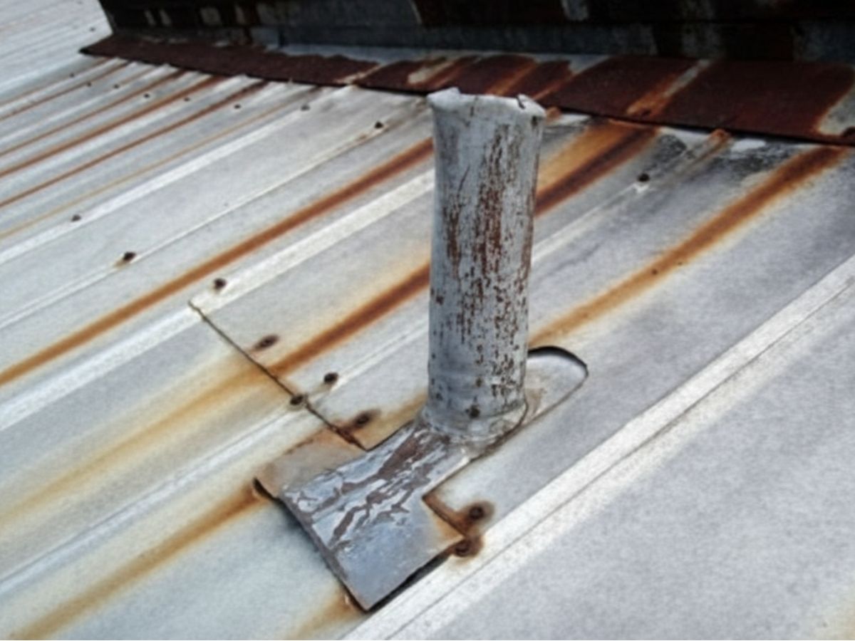 Corroded vent pipe flashing on metal roof
