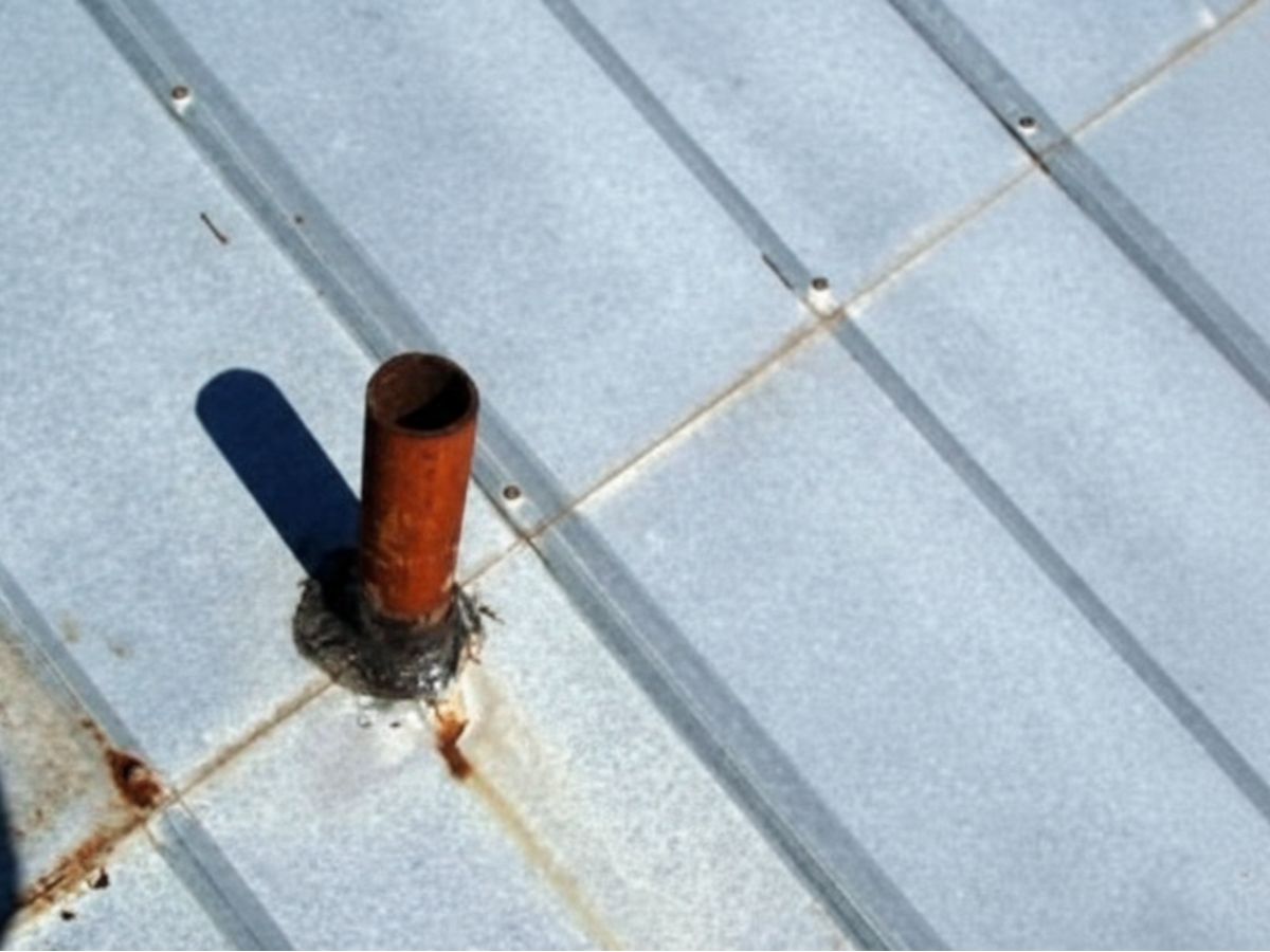 Rust stains spreading from metal roof fastener