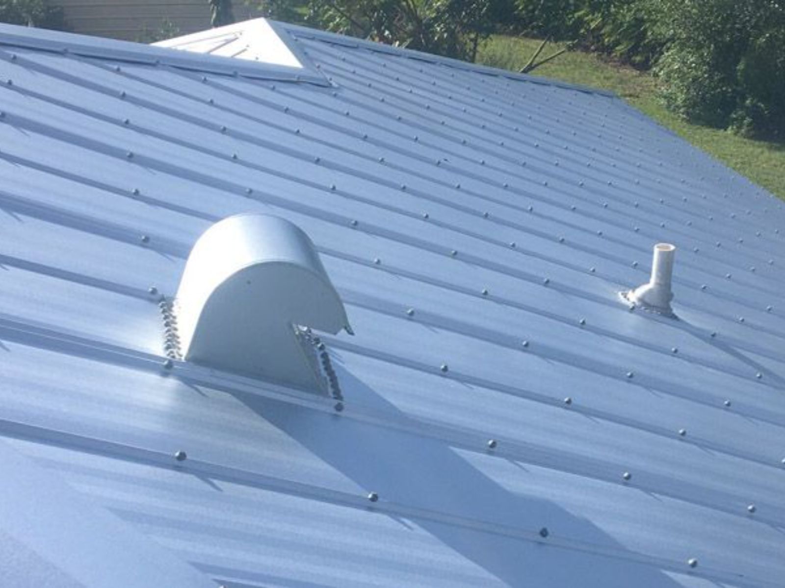 Standing seam metal roof with ridge vent and roof ventilation components installed for improved airflow and moisture control