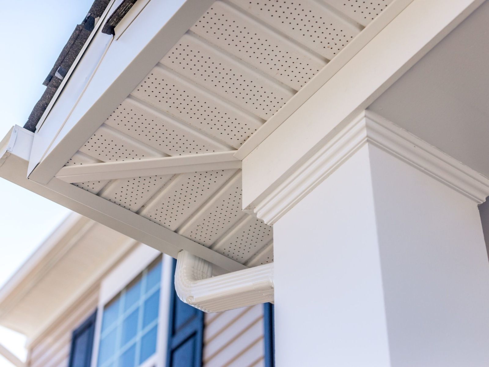 Home exterior showing soffit and fascia with aluminum gutter and downspout installed for proper roof ventilation and rainwater drainage