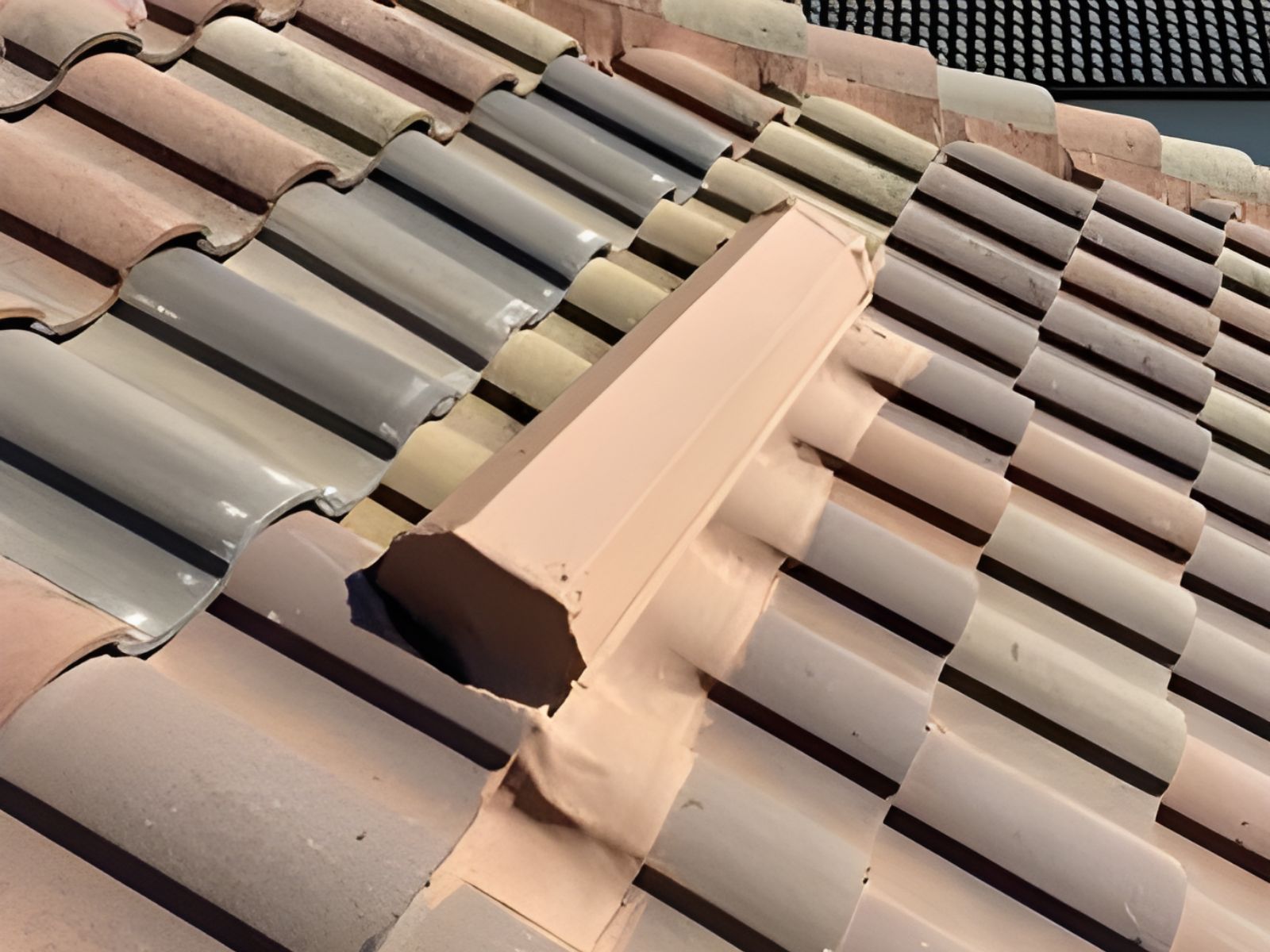 Concrete tile roof with damaged ridge cap requiring professional roof repair and weatherproof sealing