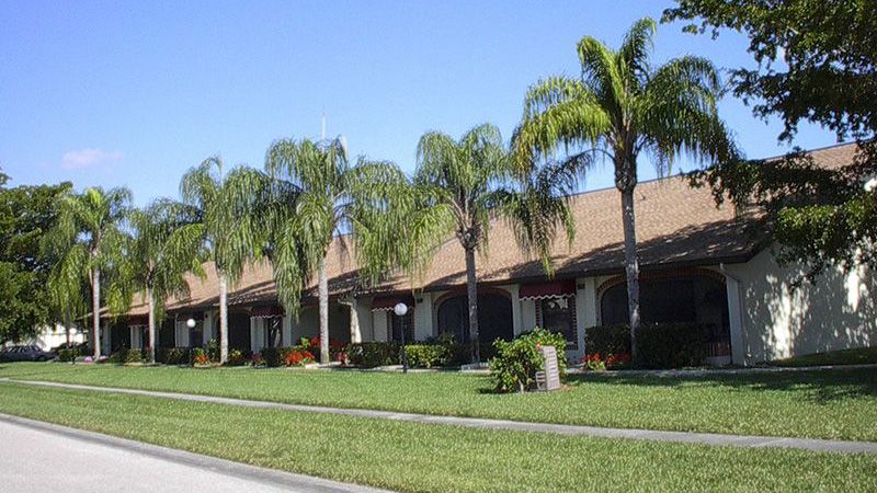 Shingle roof condos and yards lines with palm trees