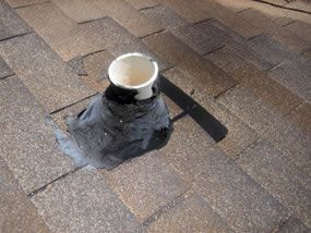 Boot flange sealed on a brown shingle roof