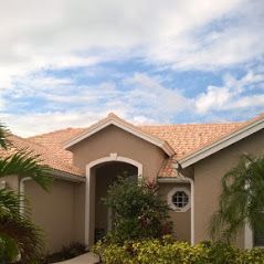 Light brown home with light tile roofing