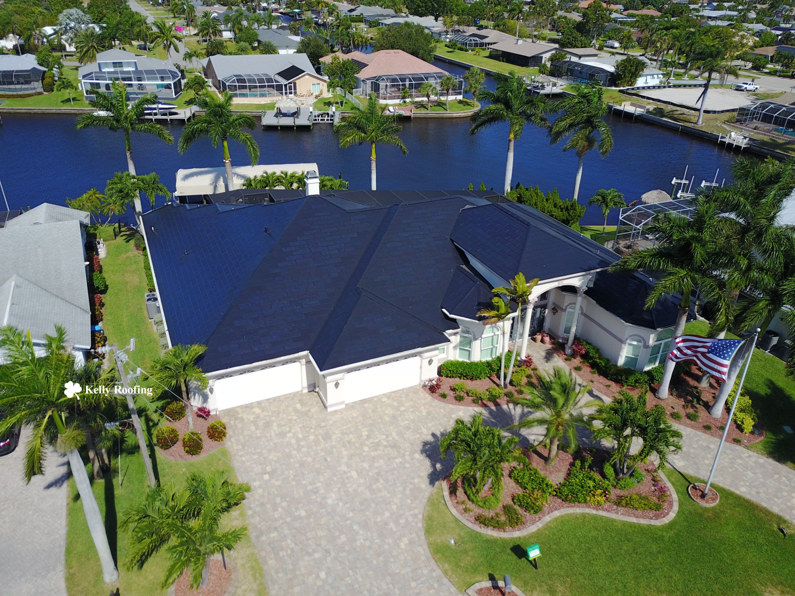A home on the edge of the water near Naples, Florida with a Tesla Solar Roof installed by Kelly Roofing.