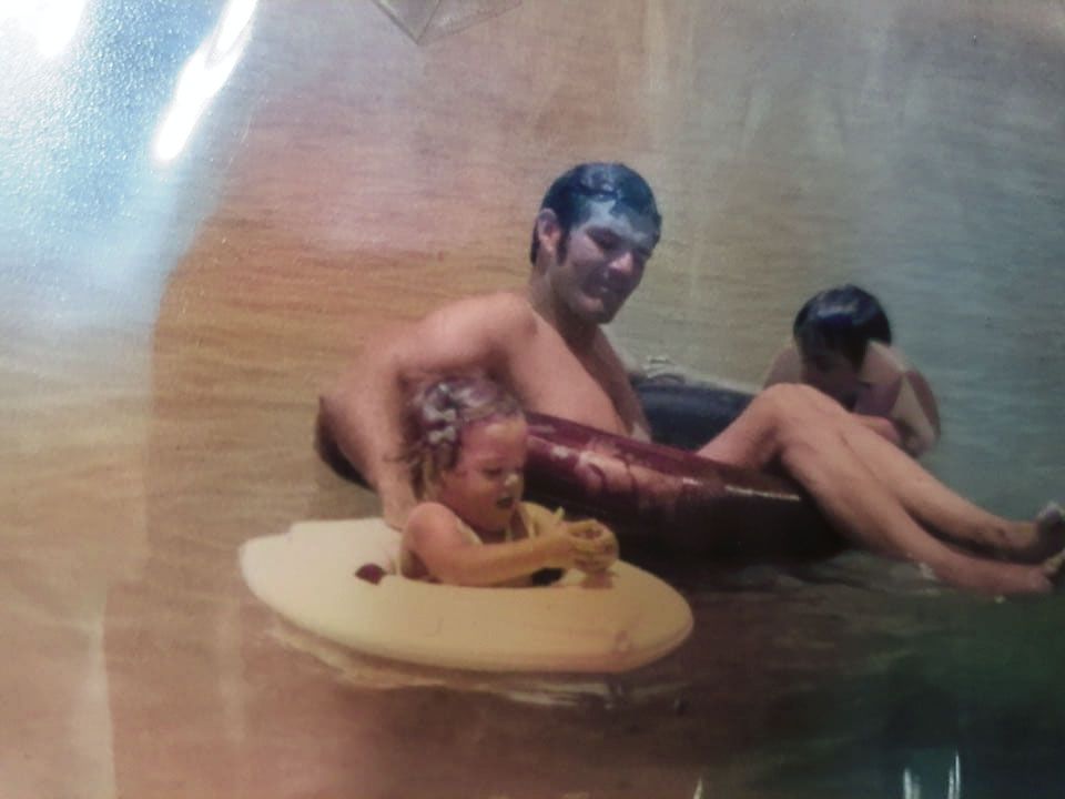 Joe Kelly, Sr with his children in inner tubes  on a lake.