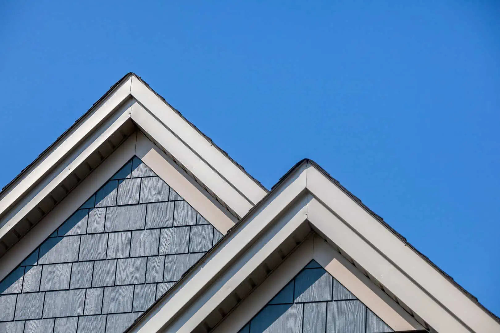 Two roofs from the front with a blue sky backdrop